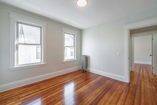 spare room with dark wood-type flooring and radiator