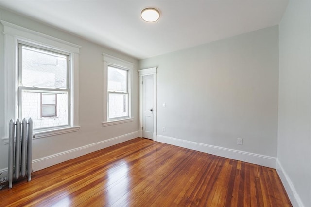 spare room featuring radiator and hardwood / wood-style flooring