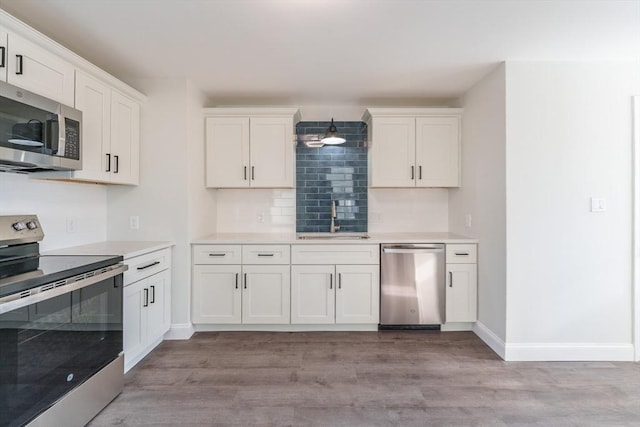 kitchen featuring white cabinetry, sink, light wood-type flooring, and appliances with stainless steel finishes