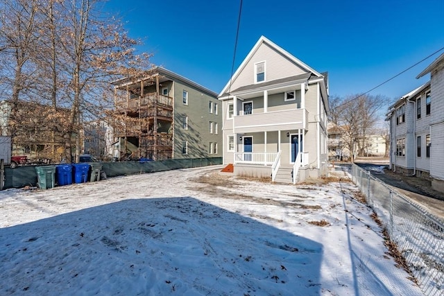 snow covered house featuring a porch