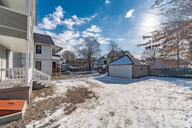 yard covered in snow featuring a garage and an outdoor structure