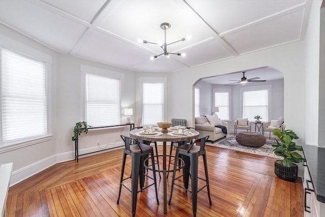 dining room featuring ceiling fan with notable chandelier, coffered ceiling, and hardwood / wood-style floors