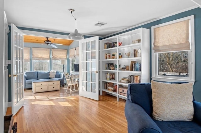 living area with french doors, vaulted ceiling, and light wood-type flooring