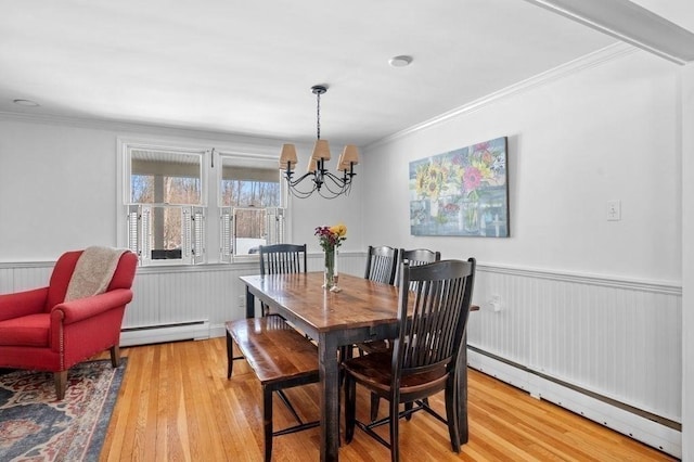 dining room featuring crown molding, a baseboard radiator, and light hardwood / wood-style floors