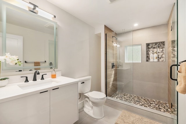 bathroom with walk in shower, vanity, toilet, and tile patterned floors