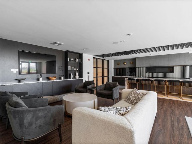 living room featuring a community bar, wood finished floors, and visible vents
