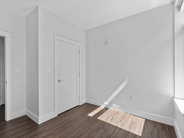 unfurnished bedroom featuring dark wood-style flooring and baseboards