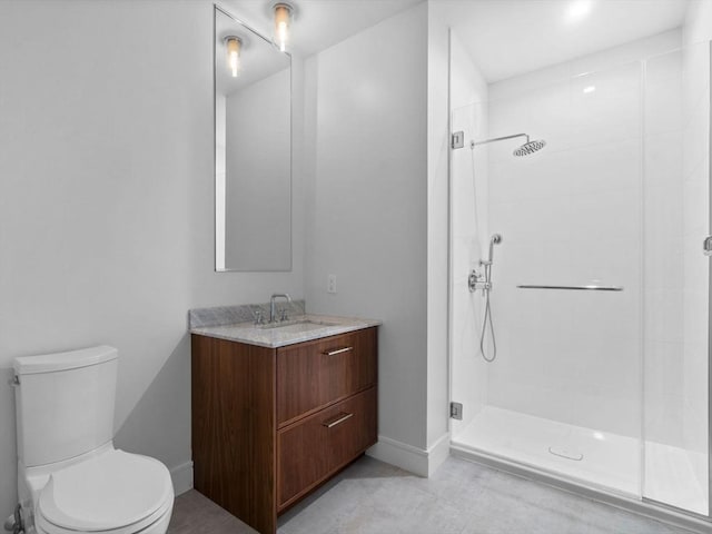 bathroom featuring a shower stall, tile patterned floors, vanity, baseboards, and toilet