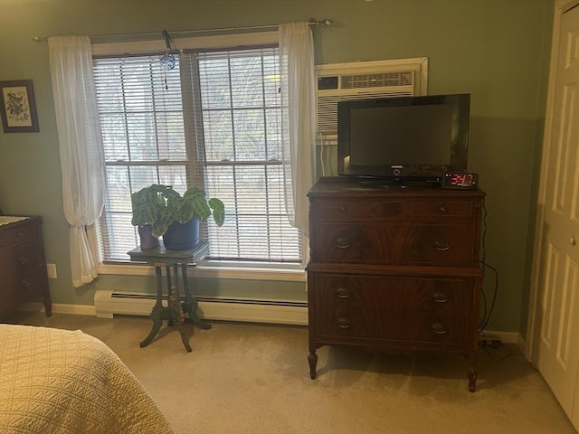 bedroom featuring light carpet, baseboards, and a baseboard heating unit