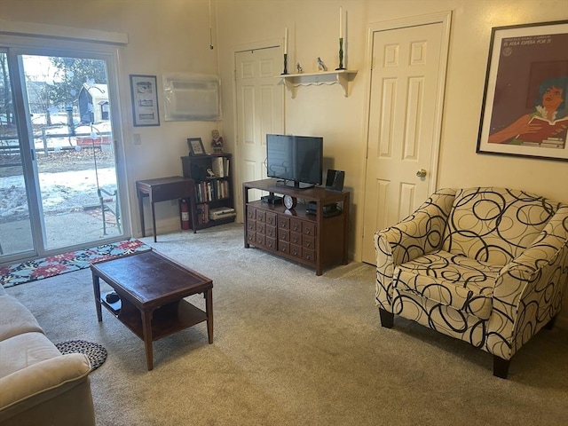 living room featuring an AC wall unit and light colored carpet