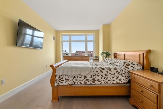 bedroom featuring baseboards and wood finished floors