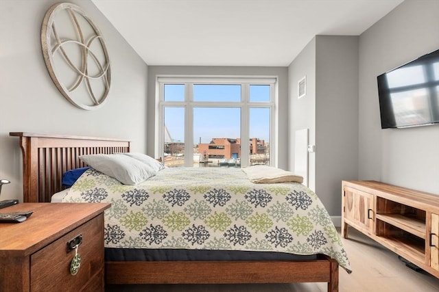 bedroom with visible vents and wood finished floors