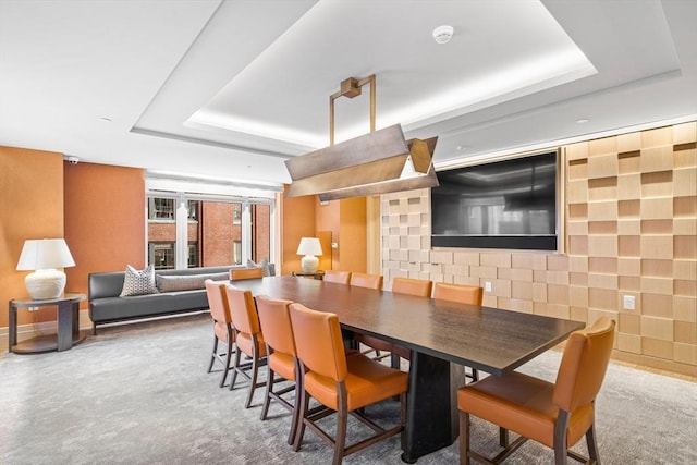 dining space with a raised ceiling and baseboards