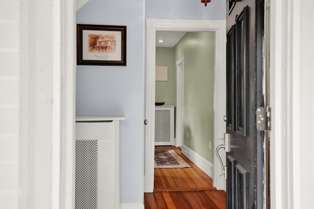 hall with dark wood-type flooring and baseboards