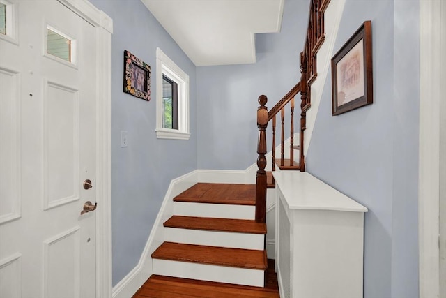 stairway featuring wood finished floors and baseboards
