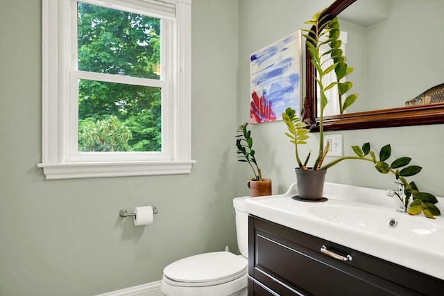 bathroom featuring toilet, healthy amount of natural light, and vanity