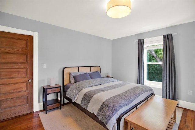 bedroom with wood finished floors and baseboards