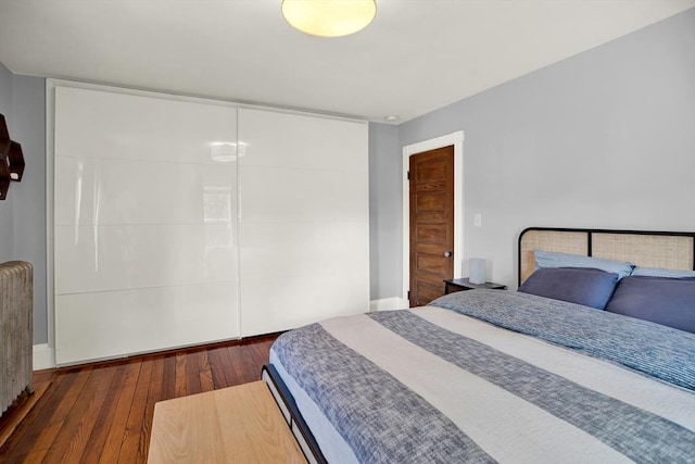 bedroom with hardwood / wood-style flooring and radiator heating unit