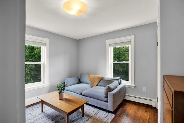 living room featuring baseboard heating, healthy amount of natural light, dark wood-style floors, and baseboards
