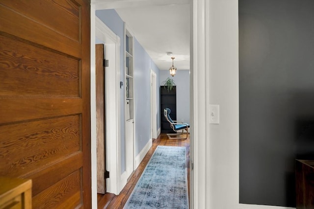 hallway with wood finished floors and baseboards