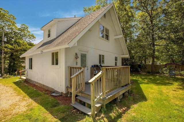 42 Beechwood Dr, Mashpee, MA 02649 - view of side of property with a wooden deck, roof with shingles, and a yard