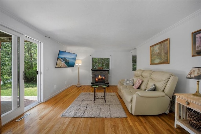 42 Beechwood Dr, Mashpee, MA 02649 - living area featuring plenty of natural light, a stone fireplace, light wood-style flooring, and crown molding