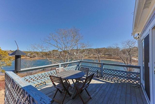 deck featuring outdoor dining space and a water view