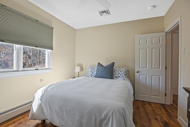 bedroom featuring ceiling fan, a baseboard radiator, wood finished floors, and visible vents