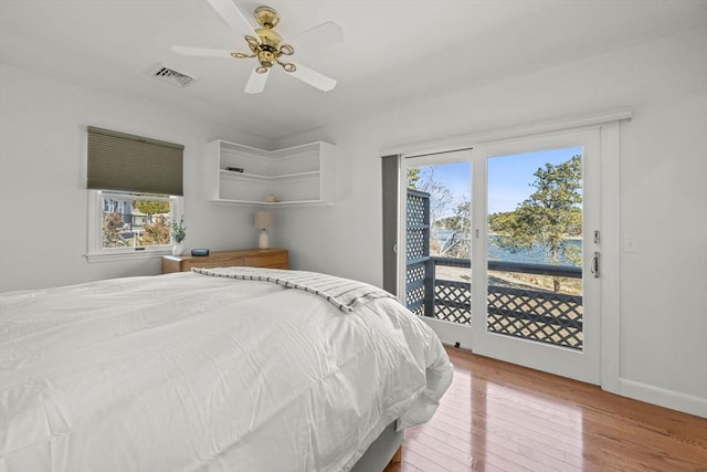 bedroom featuring hardwood / wood-style flooring, visible vents, baseboards, a ceiling fan, and access to outside