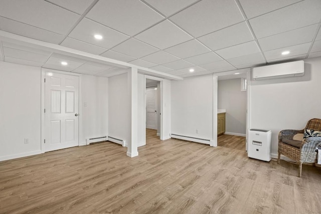 finished below grade area featuring light wood-type flooring, baseboard heating, a wall mounted air conditioner, and recessed lighting