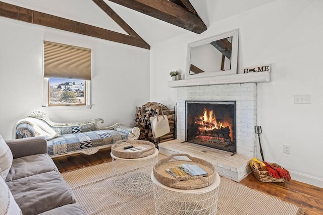 living area with a brick fireplace, vaulted ceiling with beams, baseboards, and wood finished floors