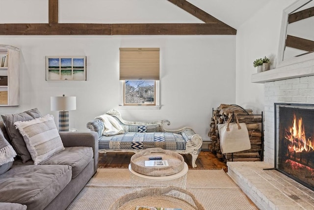 living area featuring a fireplace, beam ceiling, and wood finished floors