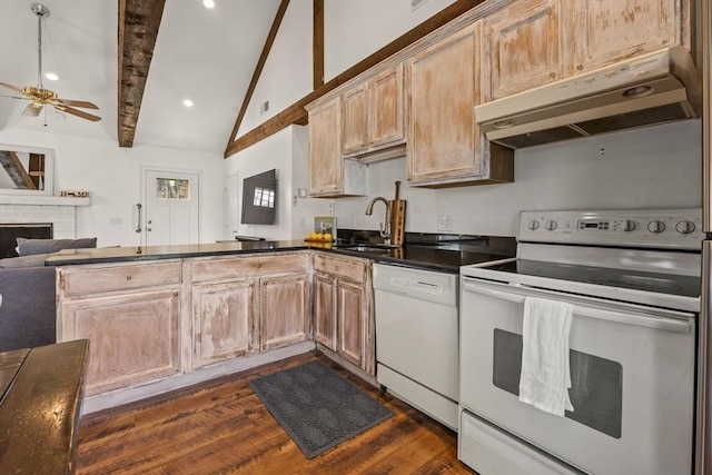 kitchen with lofted ceiling with beams, under cabinet range hood, a peninsula, white appliances, and a sink