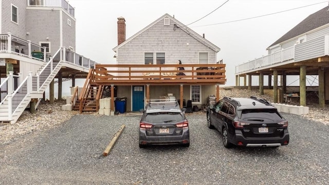 back of house featuring a wooden deck, a chimney, and stairs