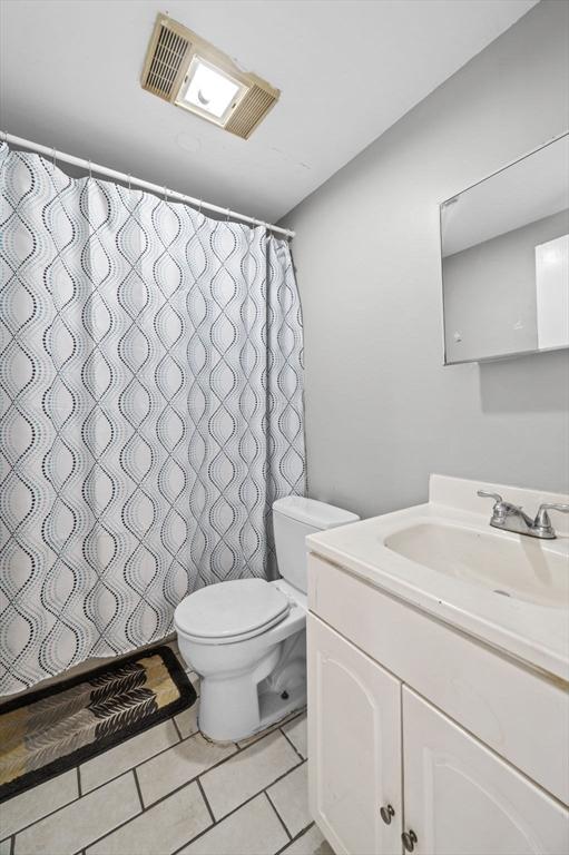 bathroom with tile patterned flooring, vanity, and toilet