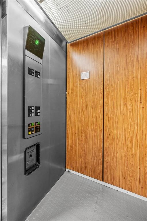 room details featuring elevator and wooden walls