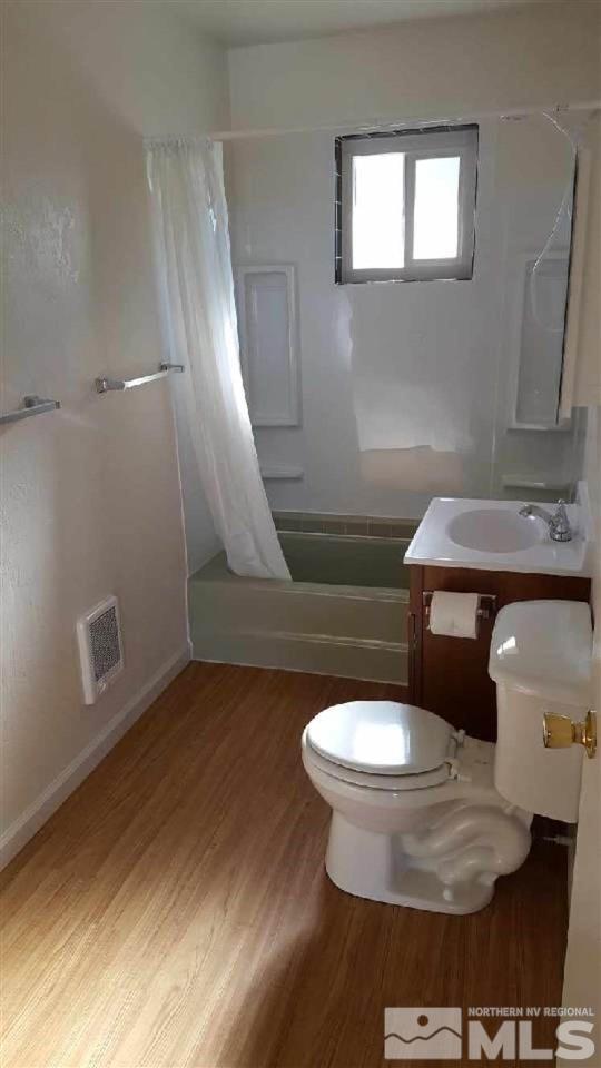 full bathroom with toilet, shower / bath combo, hardwood / wood-style floors, and vanity