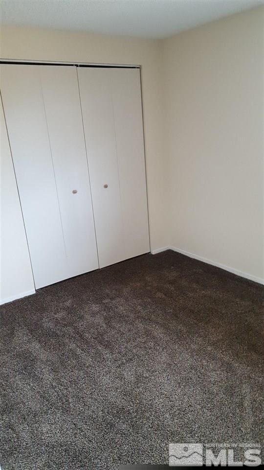unfurnished bedroom with carpet and a closet