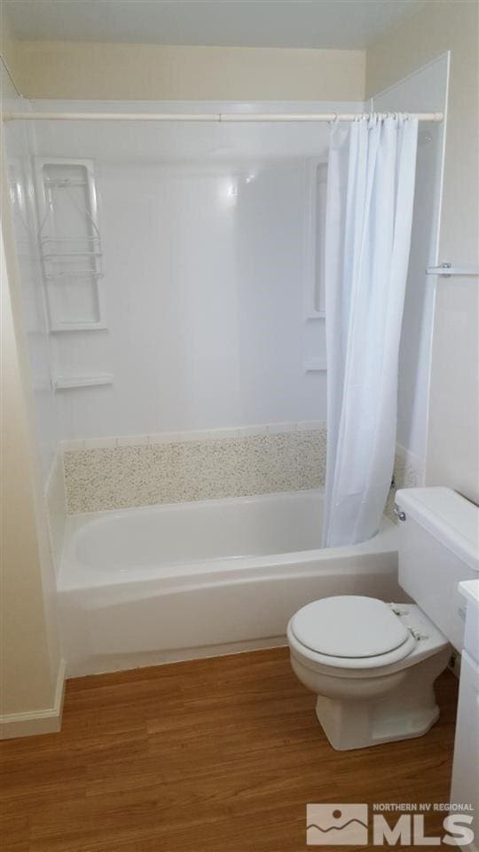 full bathroom featuring shower / bath combo with shower curtain, toilet, vanity, and wood-type flooring