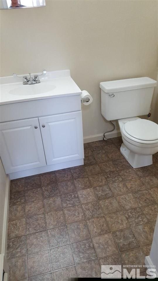 bathroom with tile flooring, toilet, and vanity