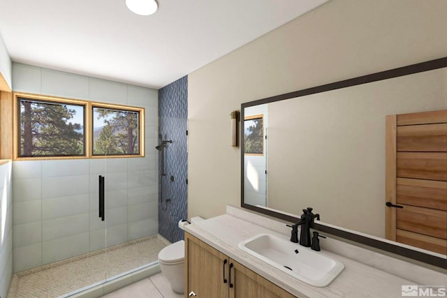 bathroom with toilet, a shower with door, tile floors, and vanity with extensive cabinet space