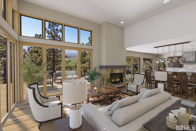 living room with a high ceiling, light hardwood / wood-style floors, and an inviting chandelier