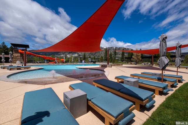 view of swimming pool with pool water feature and a patio area