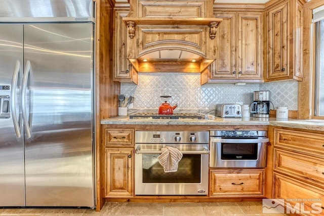 kitchen featuring light tile flooring, stainless steel appliances, tasteful backsplash, and custom range hood