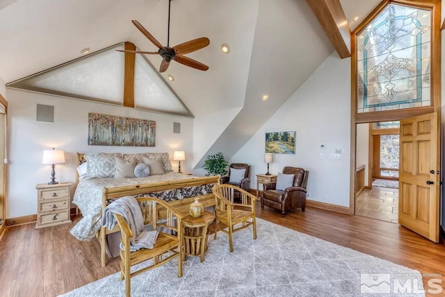 bedroom with ceiling fan, high vaulted ceiling, light wood-type flooring, and beamed ceiling