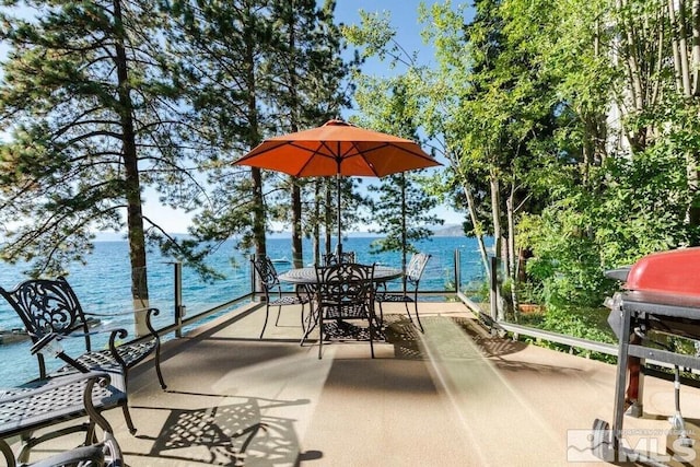 view of terrace featuring a boat dock, a water view, and grilling area