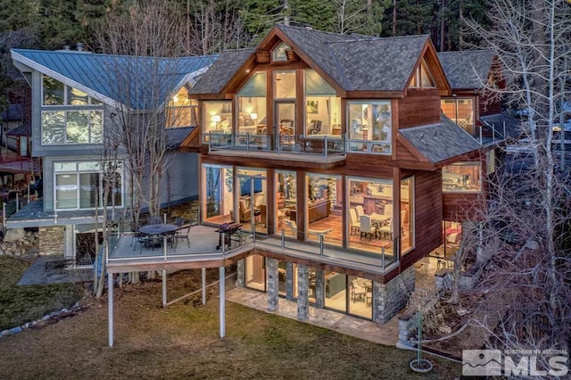 rear view of house featuring a balcony and a patio