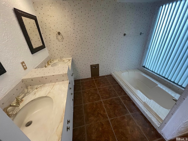 bathroom featuring tile floors, a bathing tub, and vanity