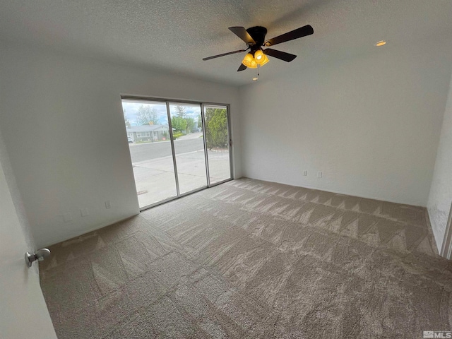 empty room with ceiling fan, a textured ceiling, and carpet