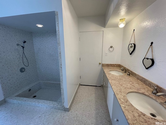 bathroom featuring double sink vanity, tile floors, and a tile shower